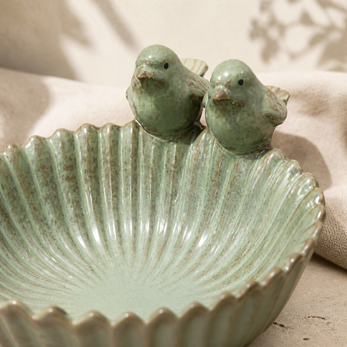 Close detail of paired ceramic birds and scalloped reactive glaze