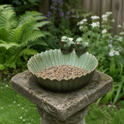 Ceramic bird feeder placed on a weathered stone garden pedestal