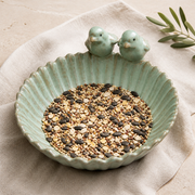 Top view of scalloped ceramic bird feeder filled with mixed birdseed